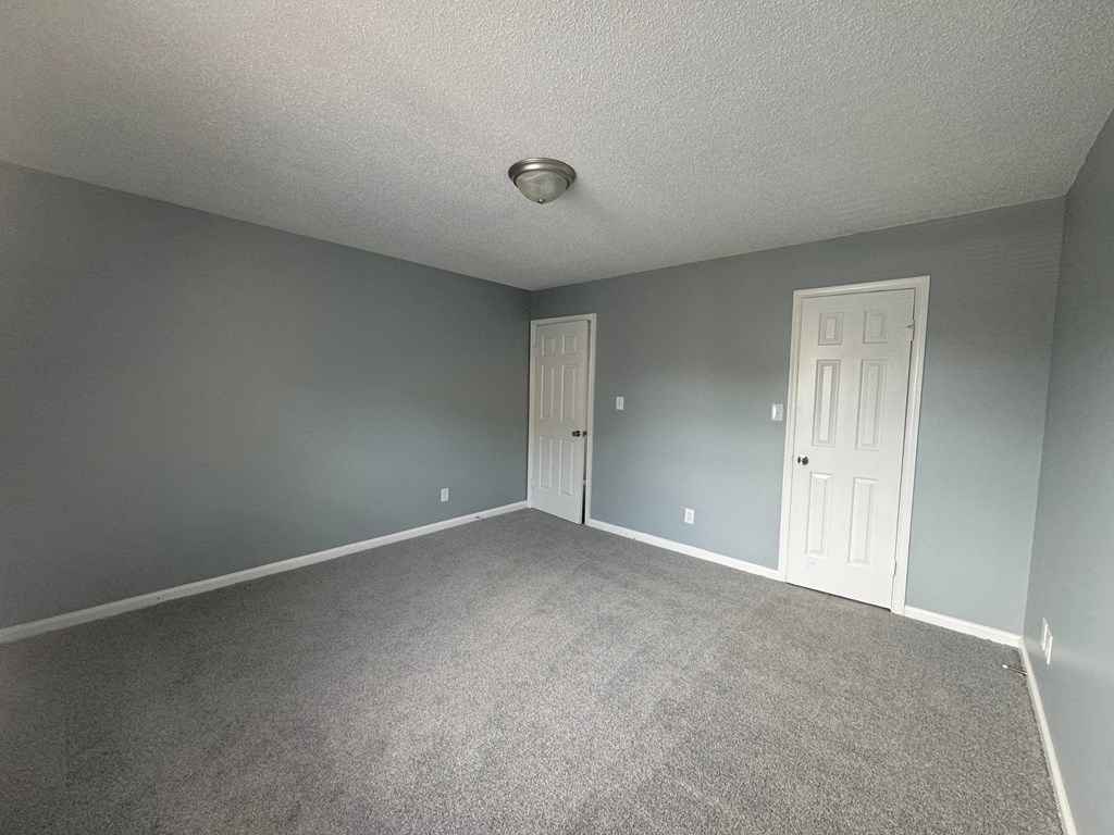 an empty room with a white door and blue walls