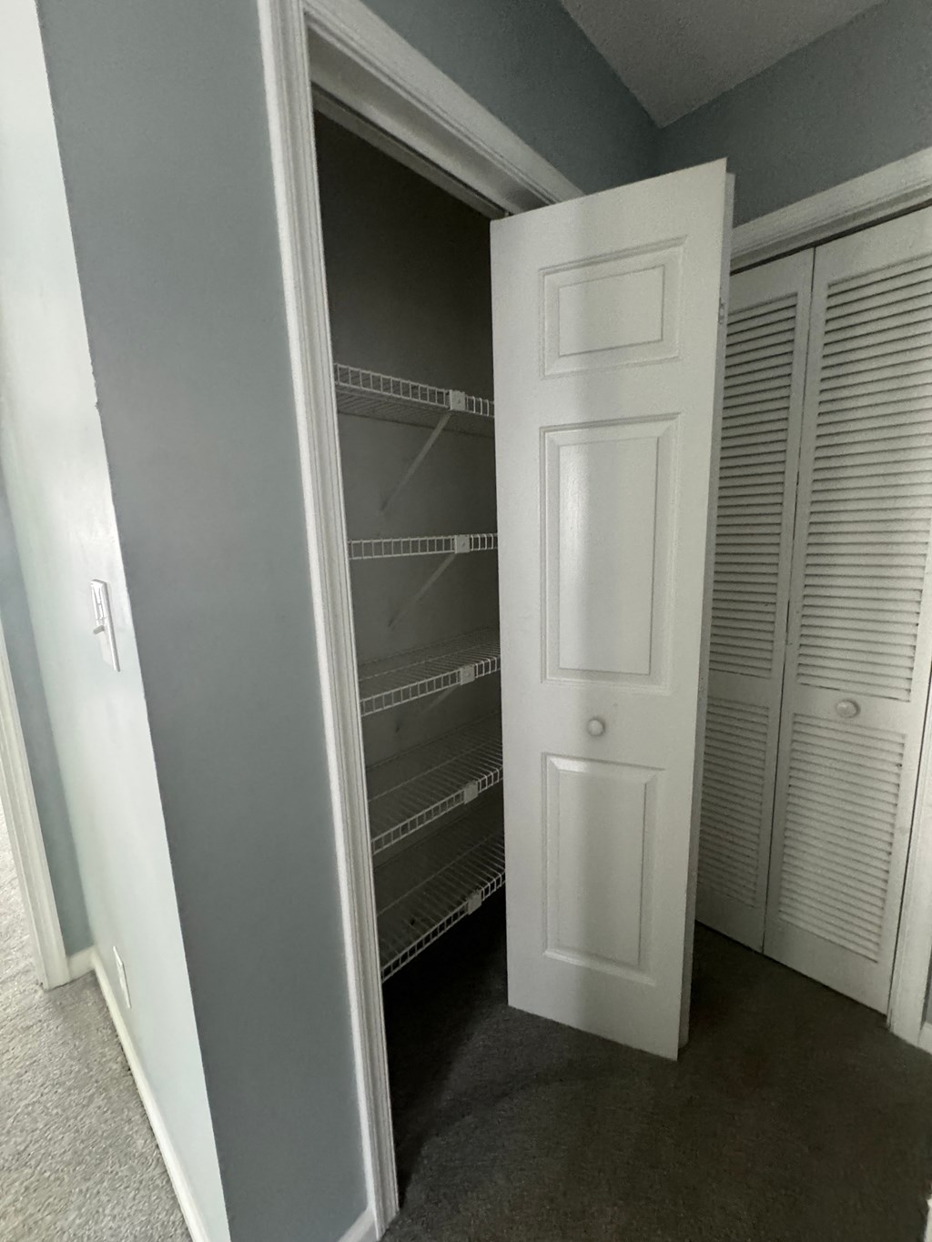 a closet with a white door and several closets