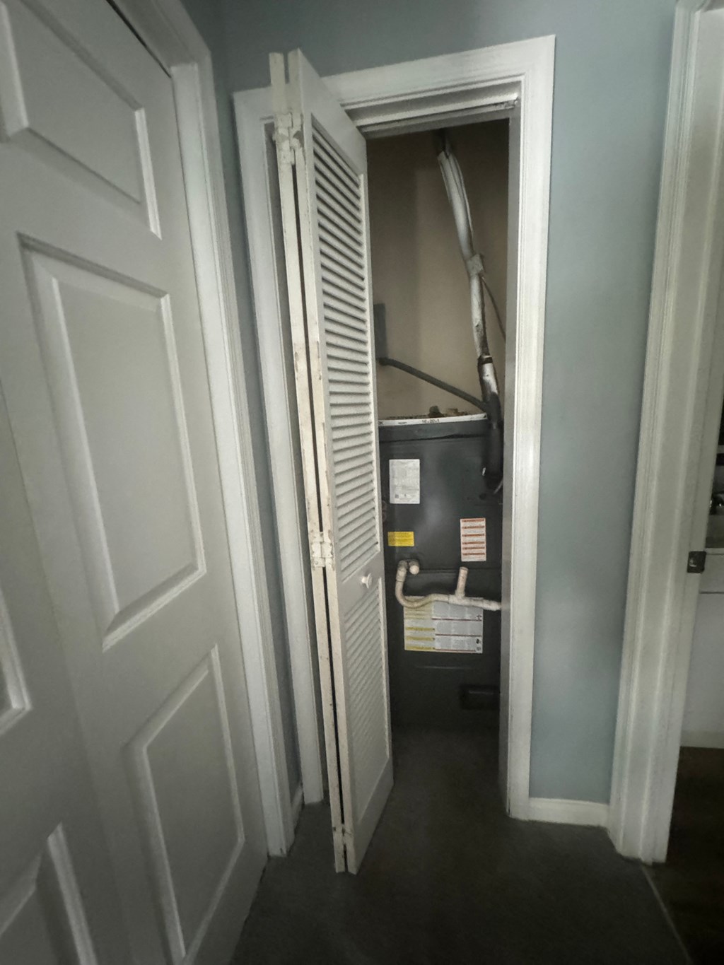 the door to the furnace is open in the hallway of a house