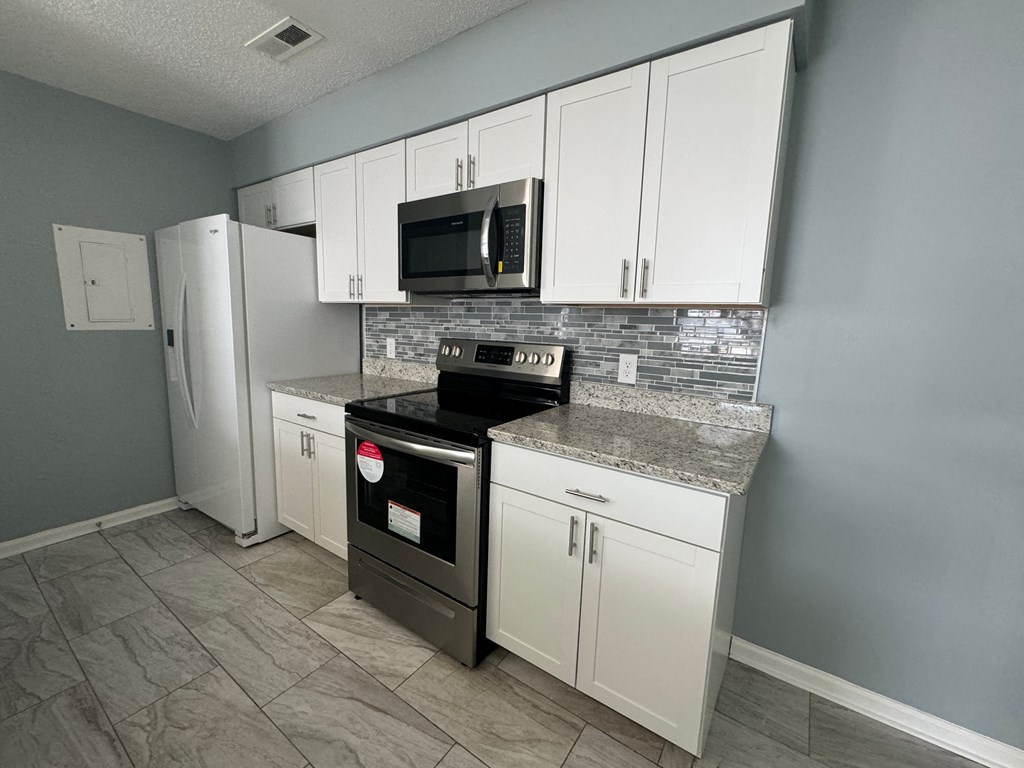 a kitchen with stainless steel appliances and white cabinets