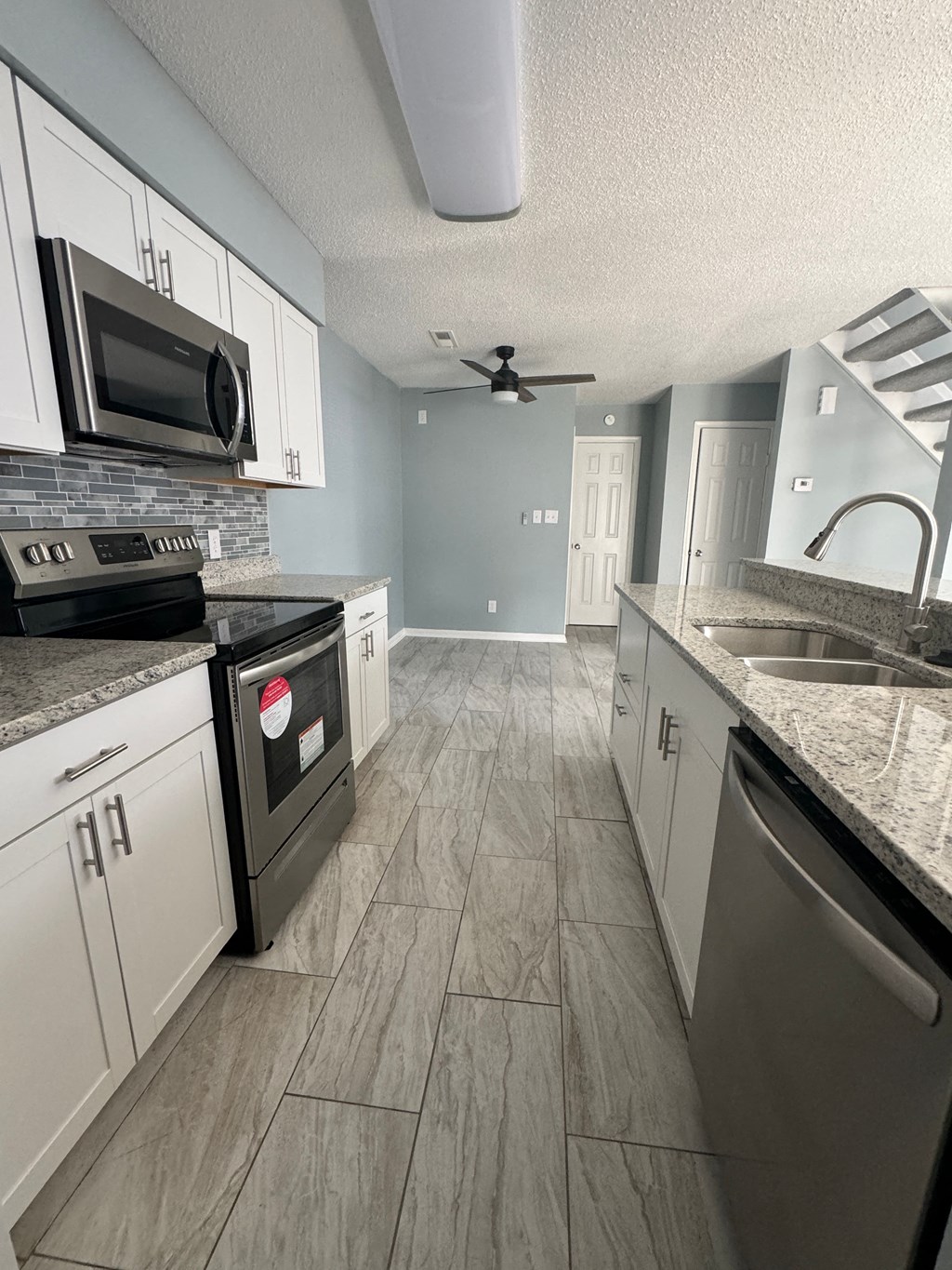 a kitchen with stainless steel appliances and white cabinets