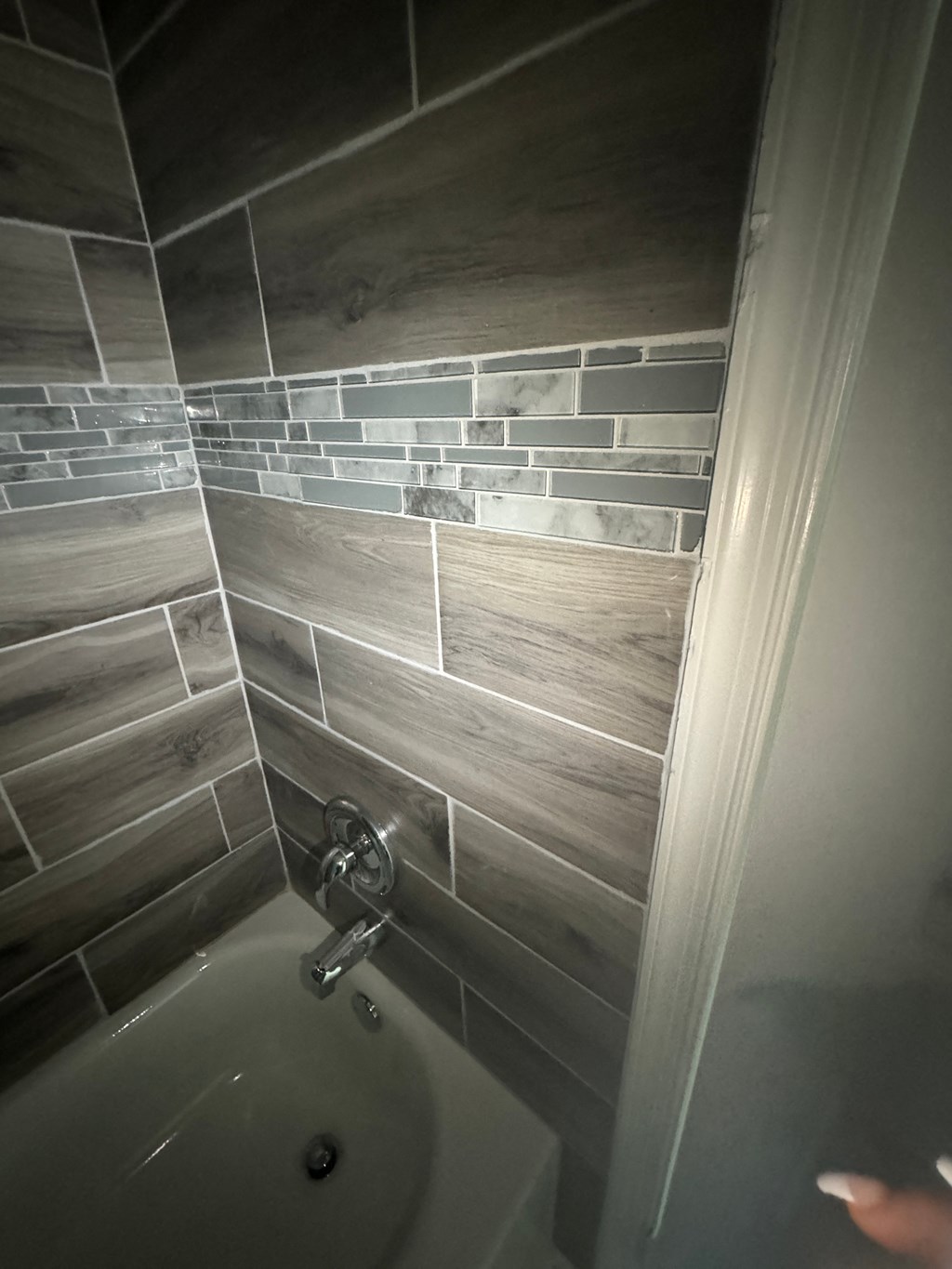 a tiled bathroom with a bath tub and a sink