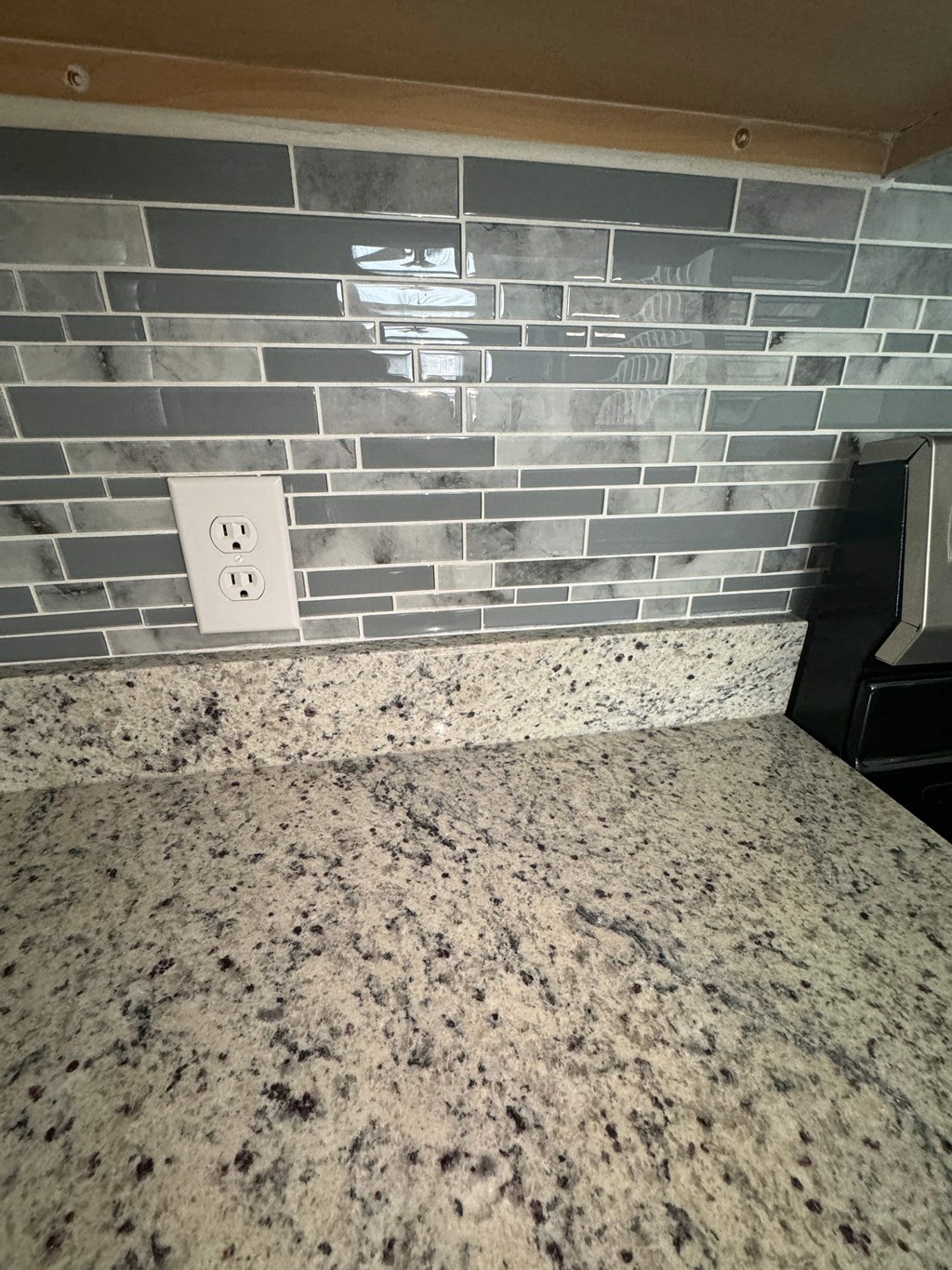 a tiled counter top in a kitchen with a light switch