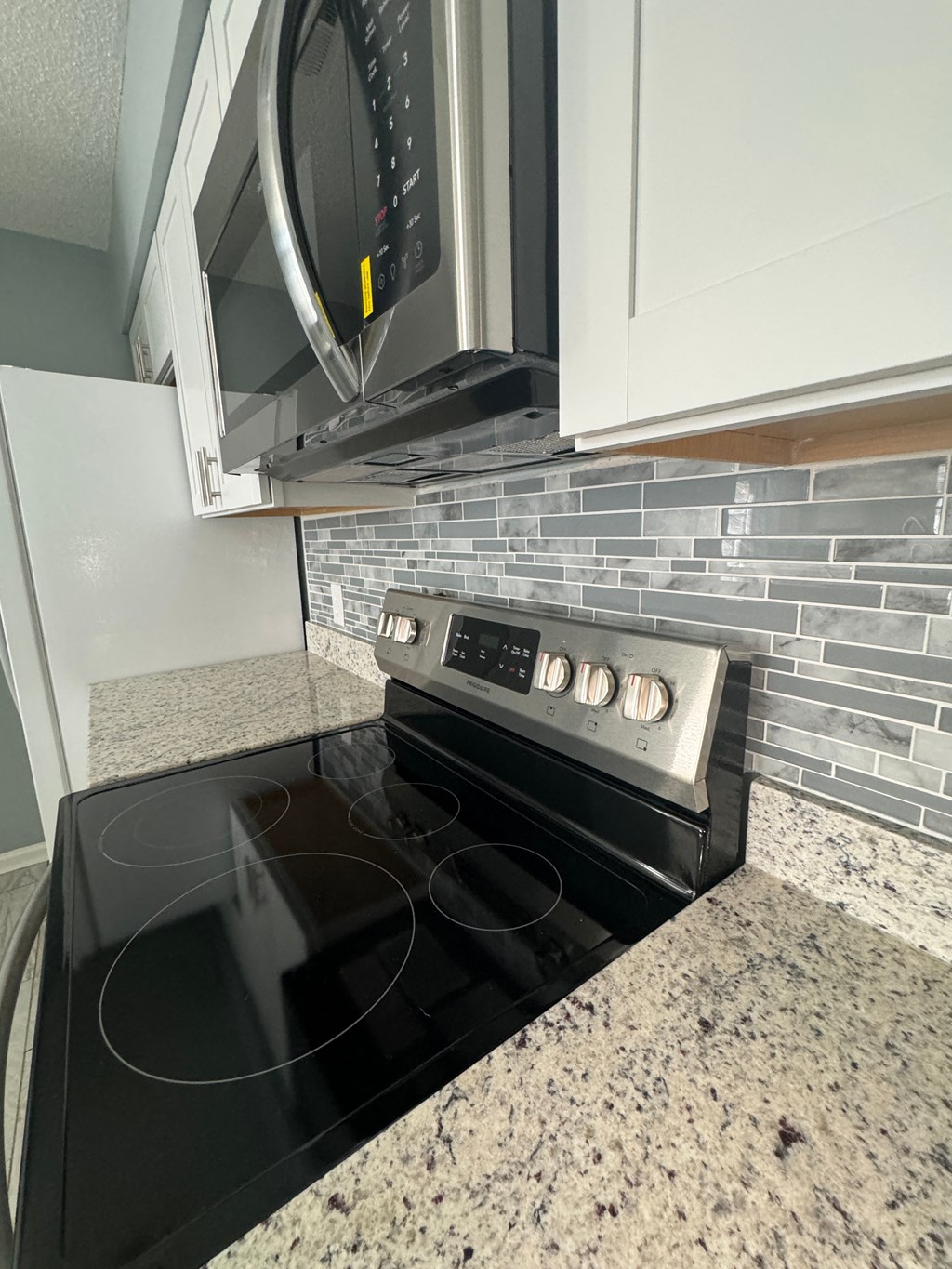 a black stove in a kitchen with a microwave