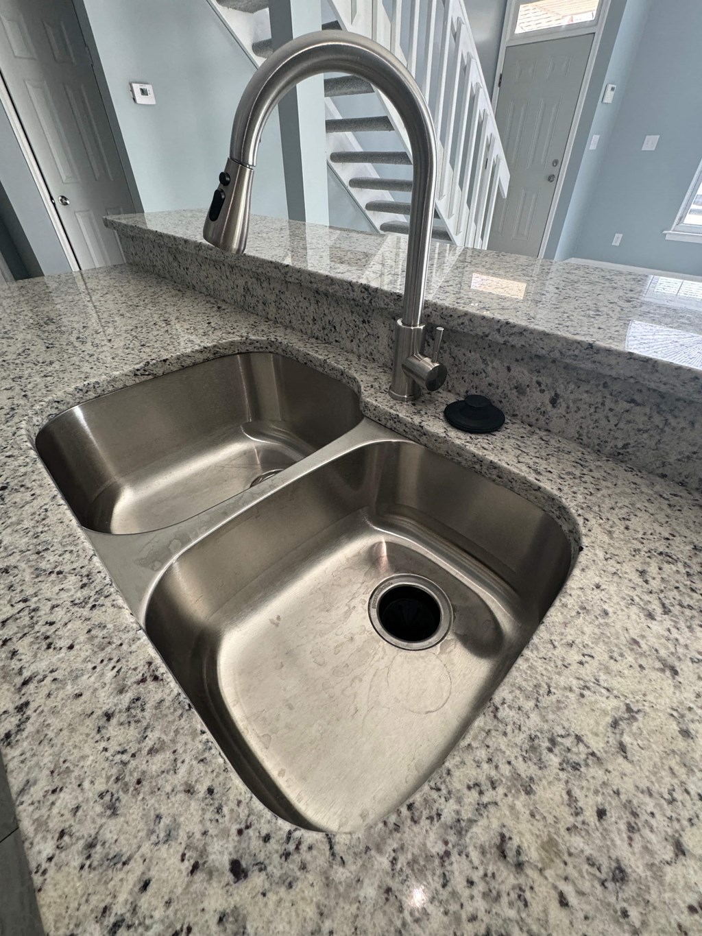 a stainless steel sink in a granite counter top