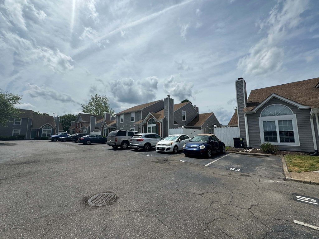 a parking lot filled with cars in front of houses