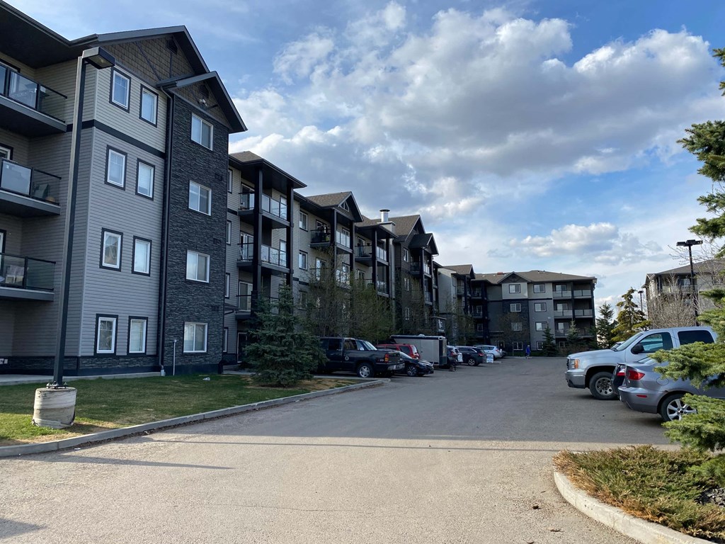 an apartment building on the side of a street with parked cars