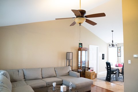 a living room with a couch and a ceiling fan