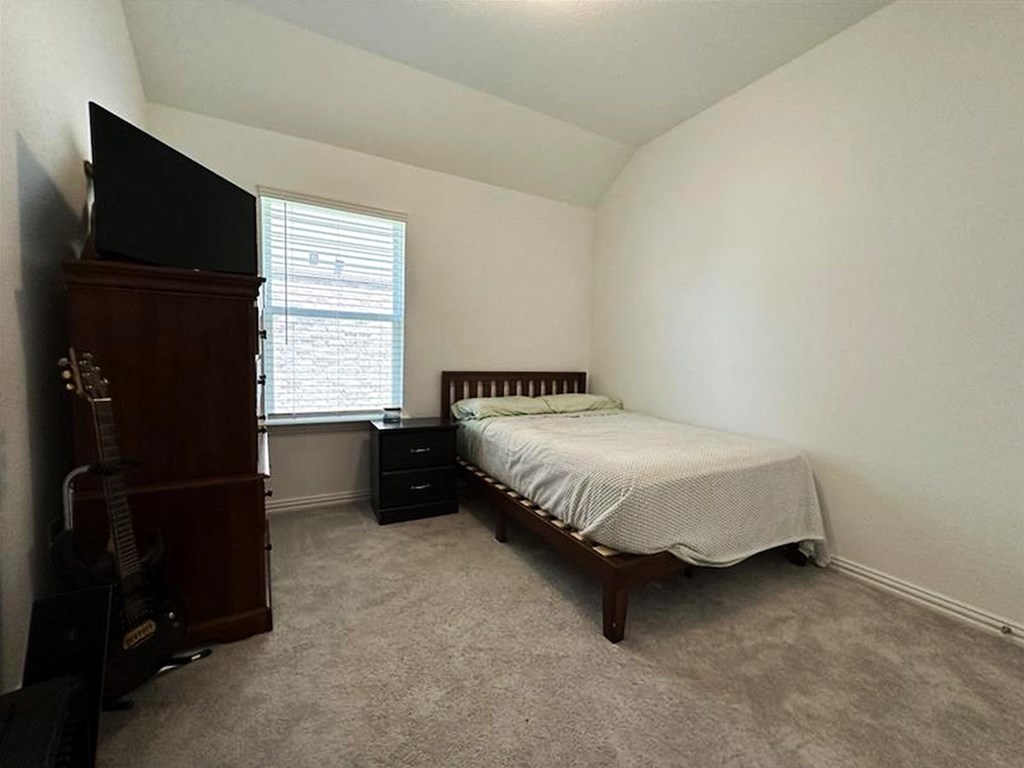 a bedroom with a bed and a guitar in it