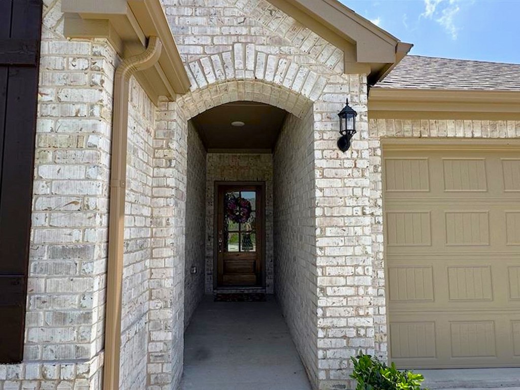 a white brick house with a walkway and a garage door