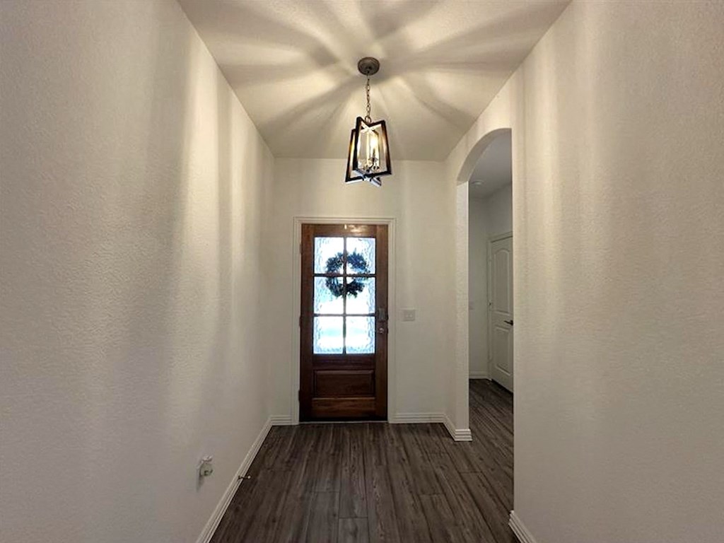 an empty hallway with a door and a light fixture