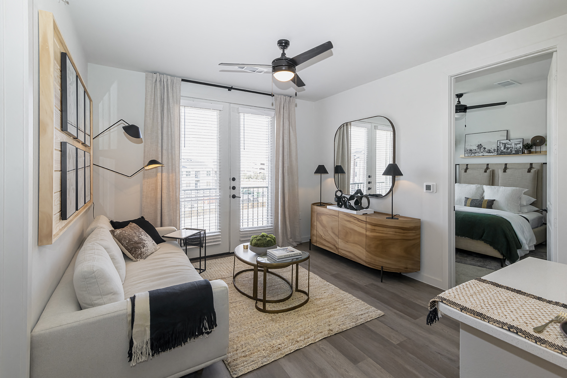 a living room with a couch and a mirror and a bed