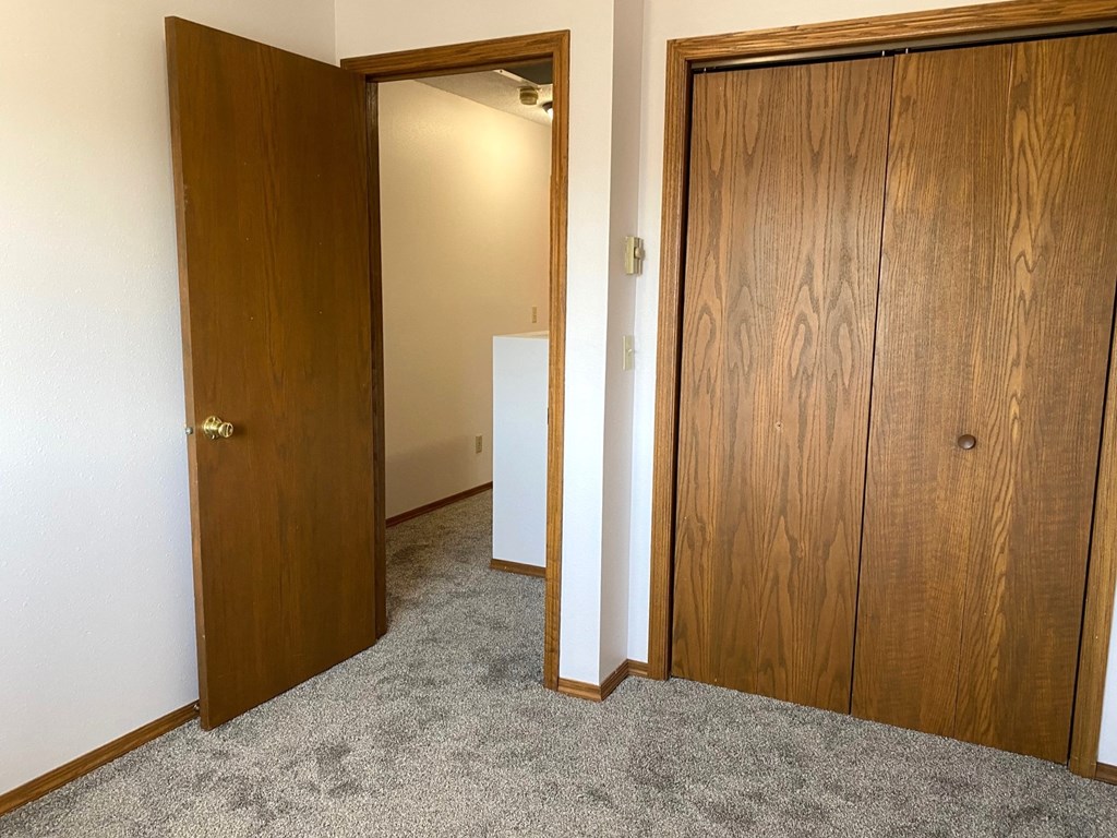 a bedroom with a closet and a door to a bathroom