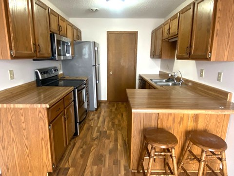 a kitchen with wooden cabinets and a stainless steel refrigerator