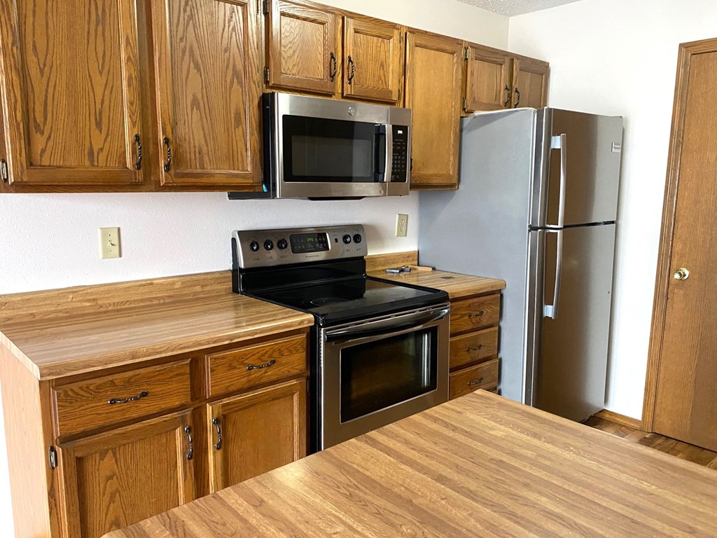 a kitchen with stainless steel appliances and wooden cabinets