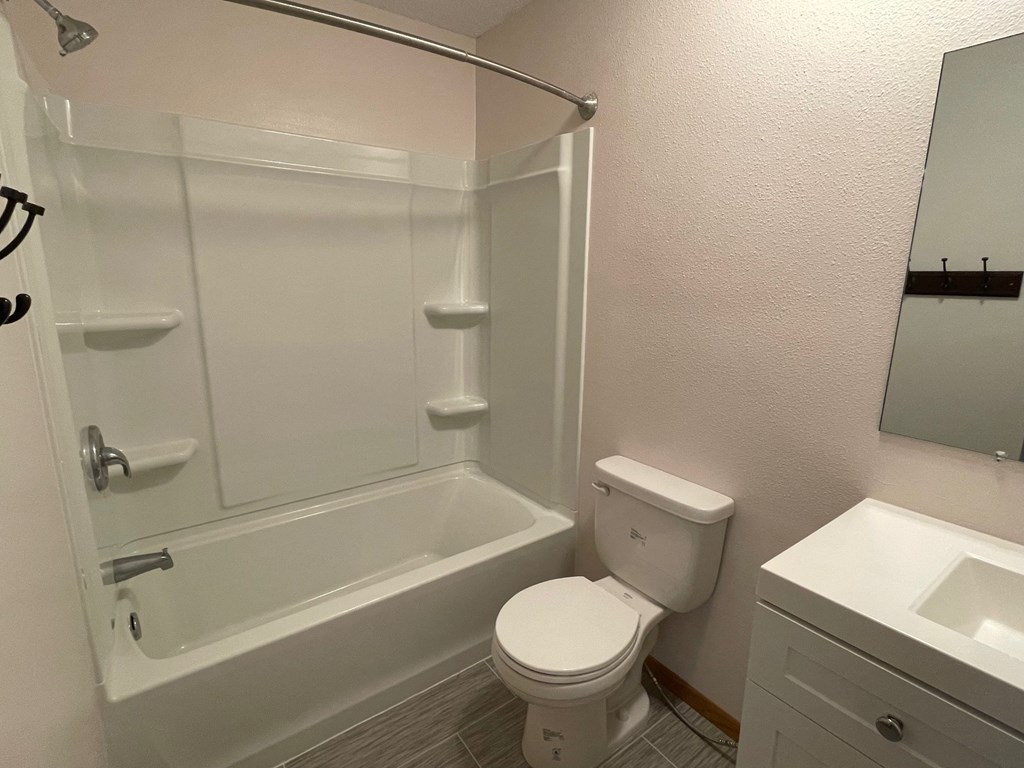 a bathroom with a shower and a toilet and a sink