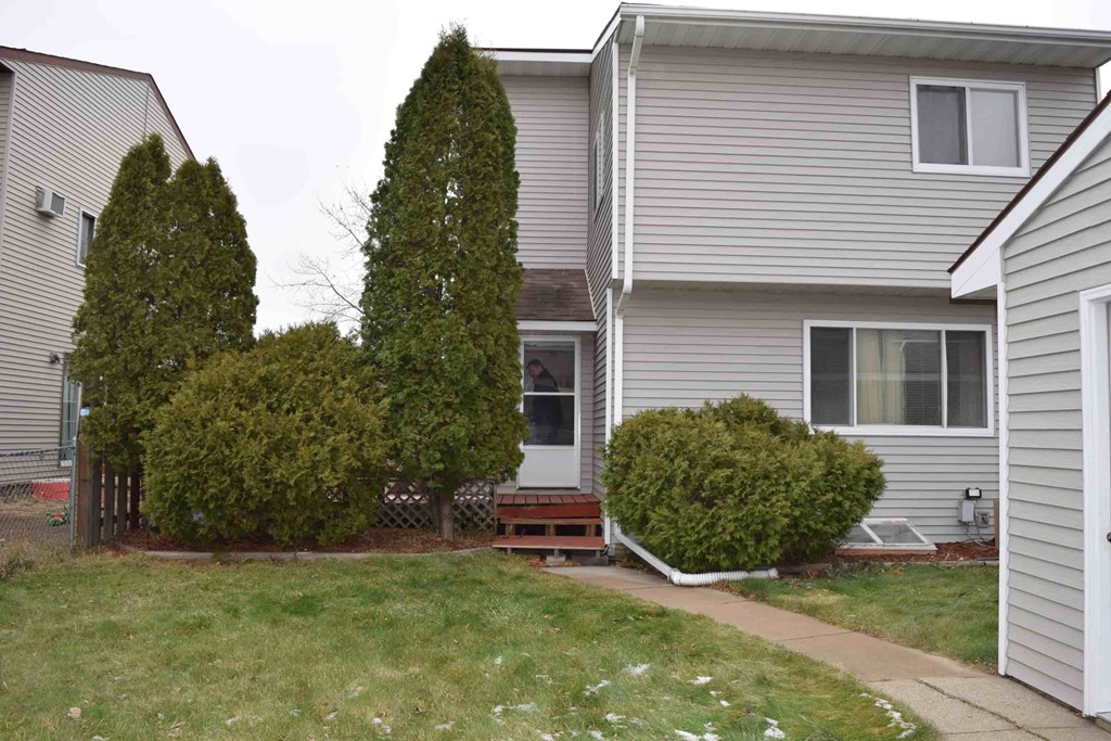 a side view of a house with a yard and a sidewalk