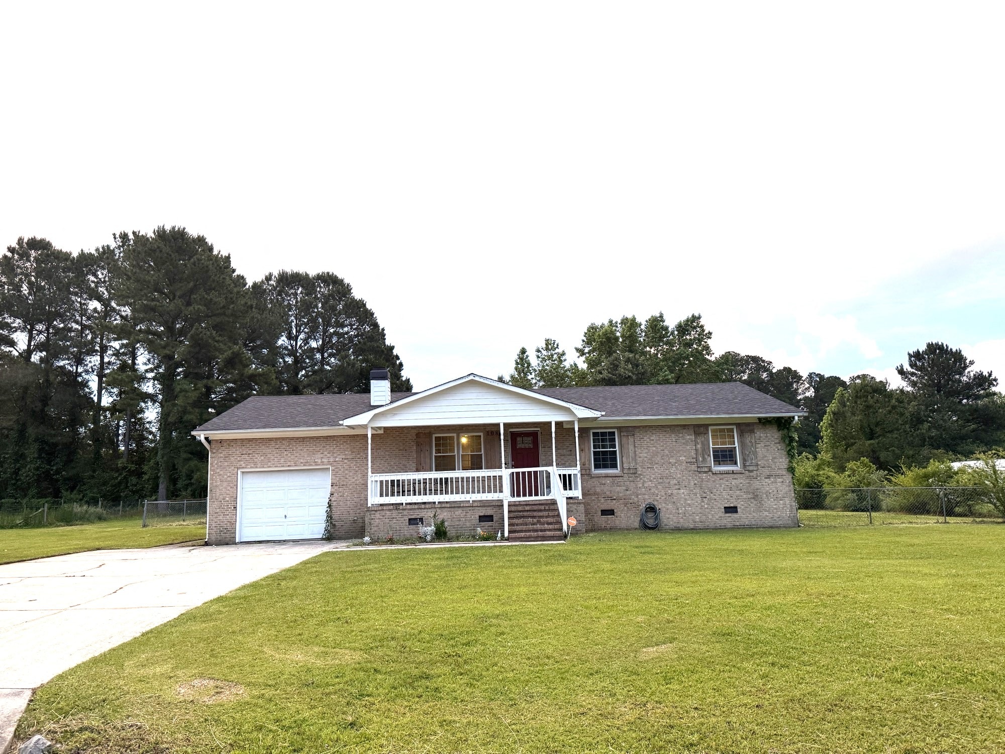 a brick house with a yard and a white garage door