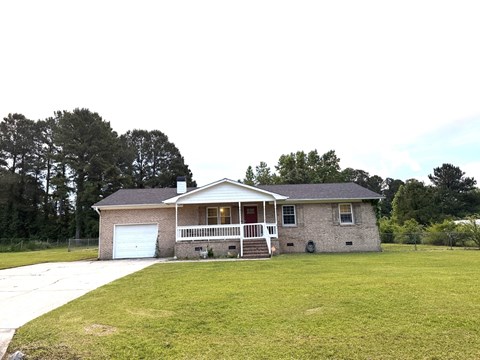 a brick house with a yard and a white garage door