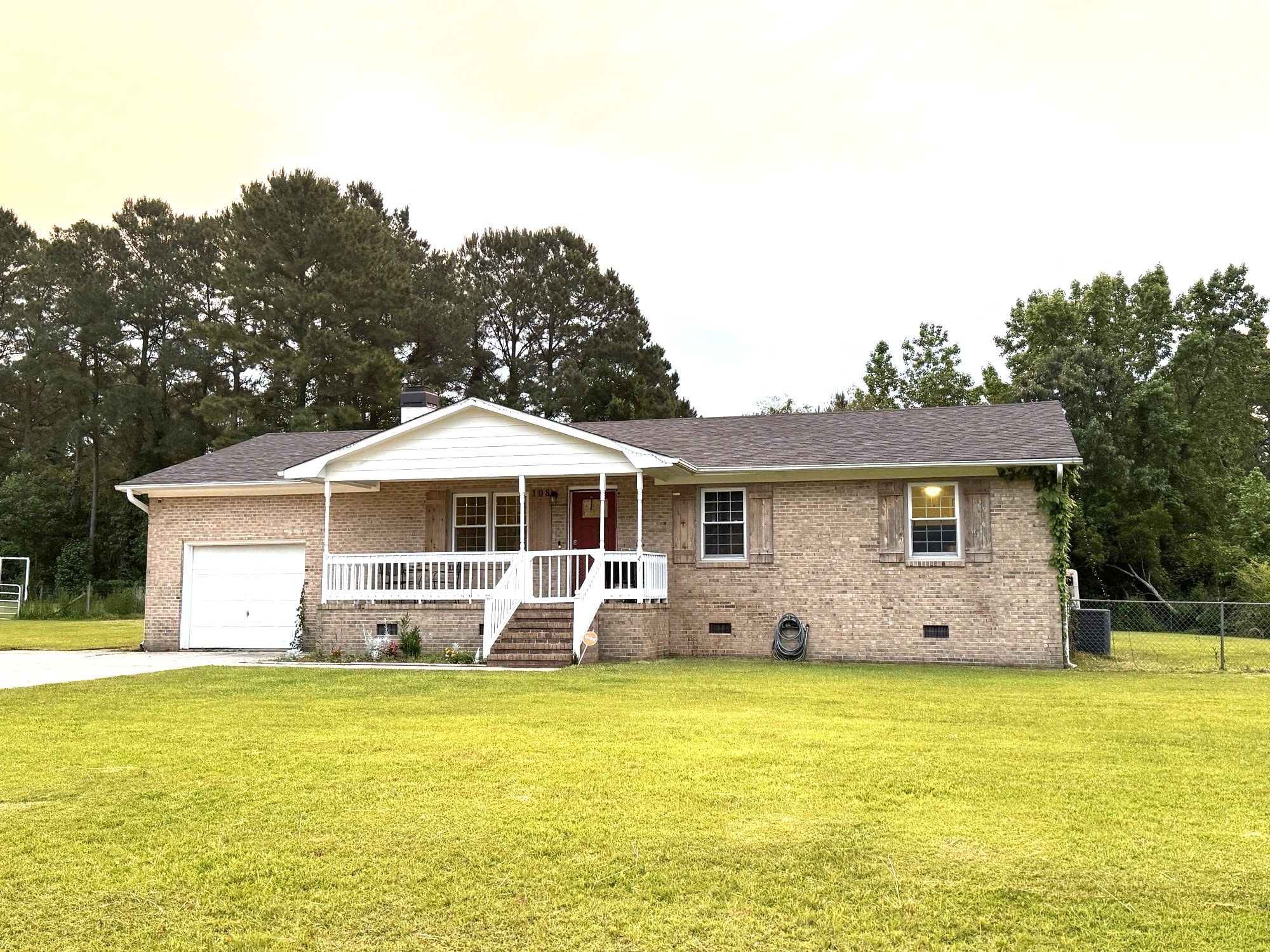 a small brick house with a yard in front of it