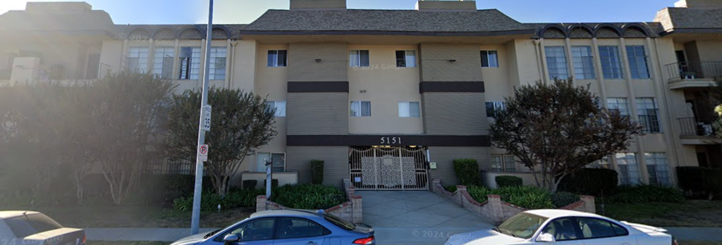 an apartment building with cars parked in front of it