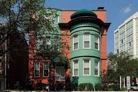 A green and red building with a tower.