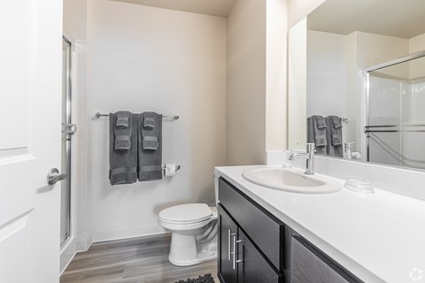 A bathroom with a toilet, sink, and towel rack.