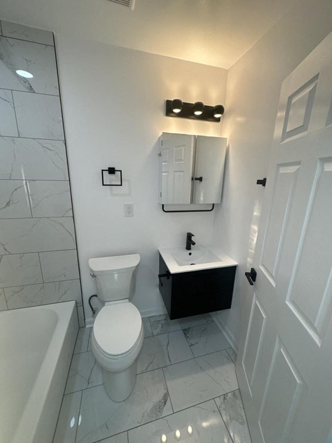 a white bathroom with a toilet and a sink