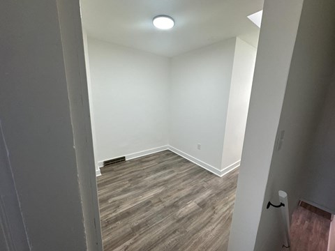 a empty room with wood flooring and white walls