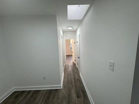 a long hallway with white walls and wood floors