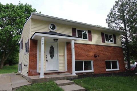 a house with a white door and a red brick facade