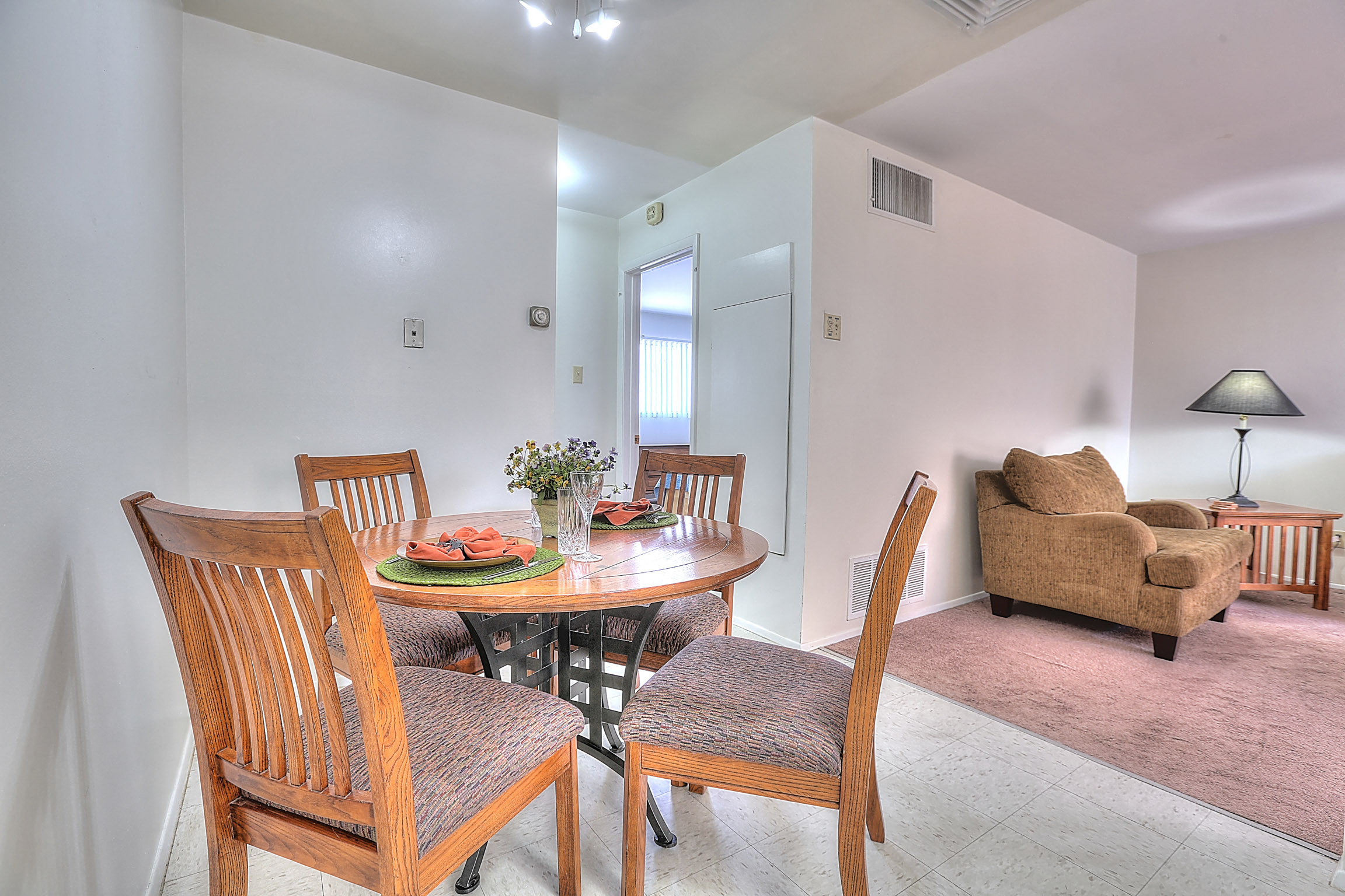 A dining room with a round table and chairs.