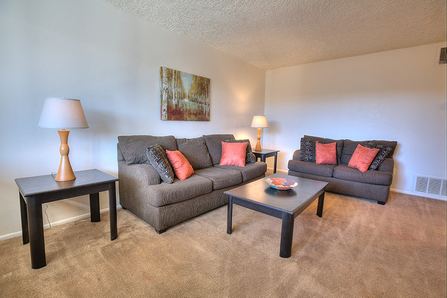 A living room with a grey couch and a small table.