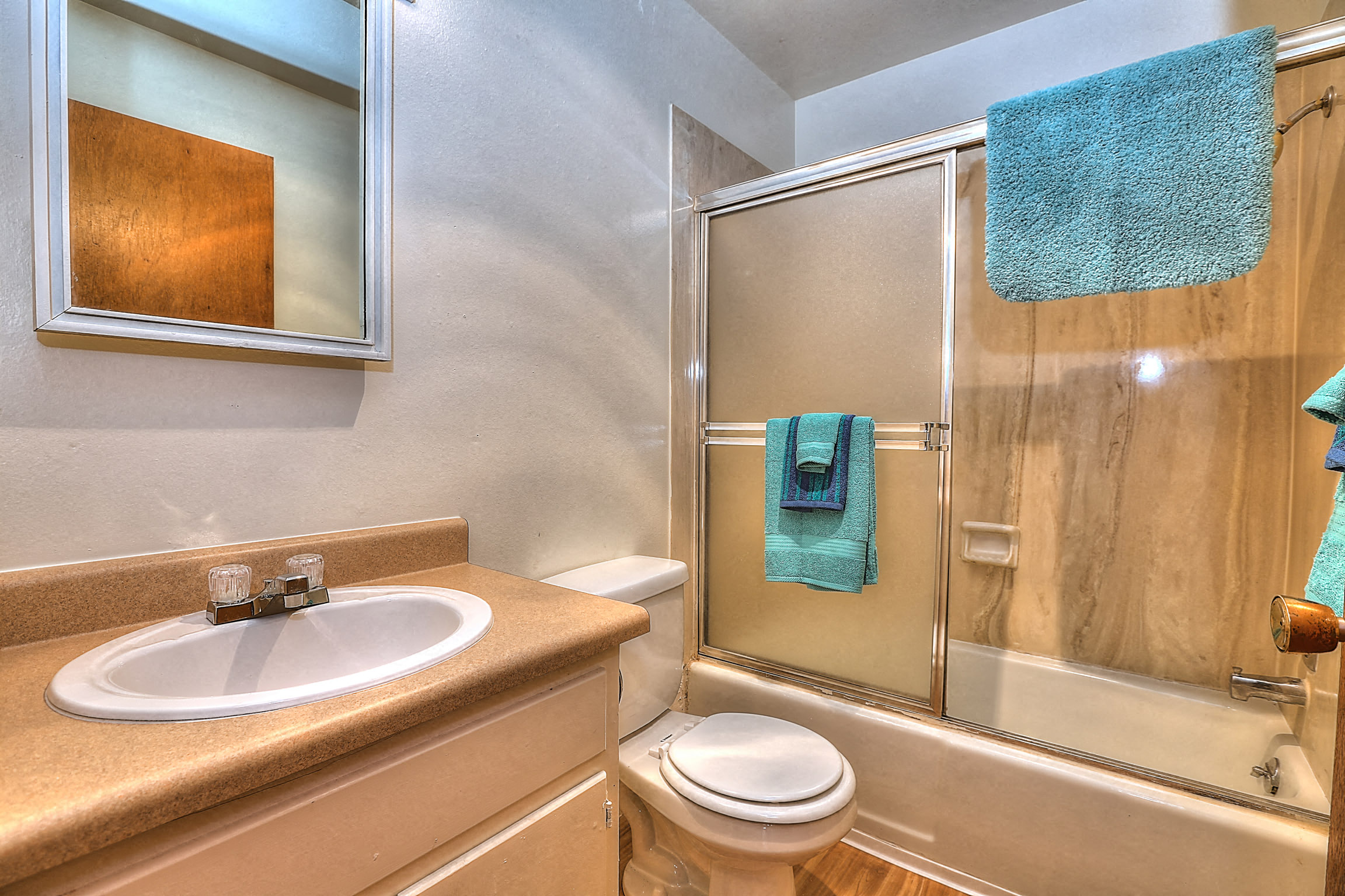 A bathroom with a toilet, sink, and shower.