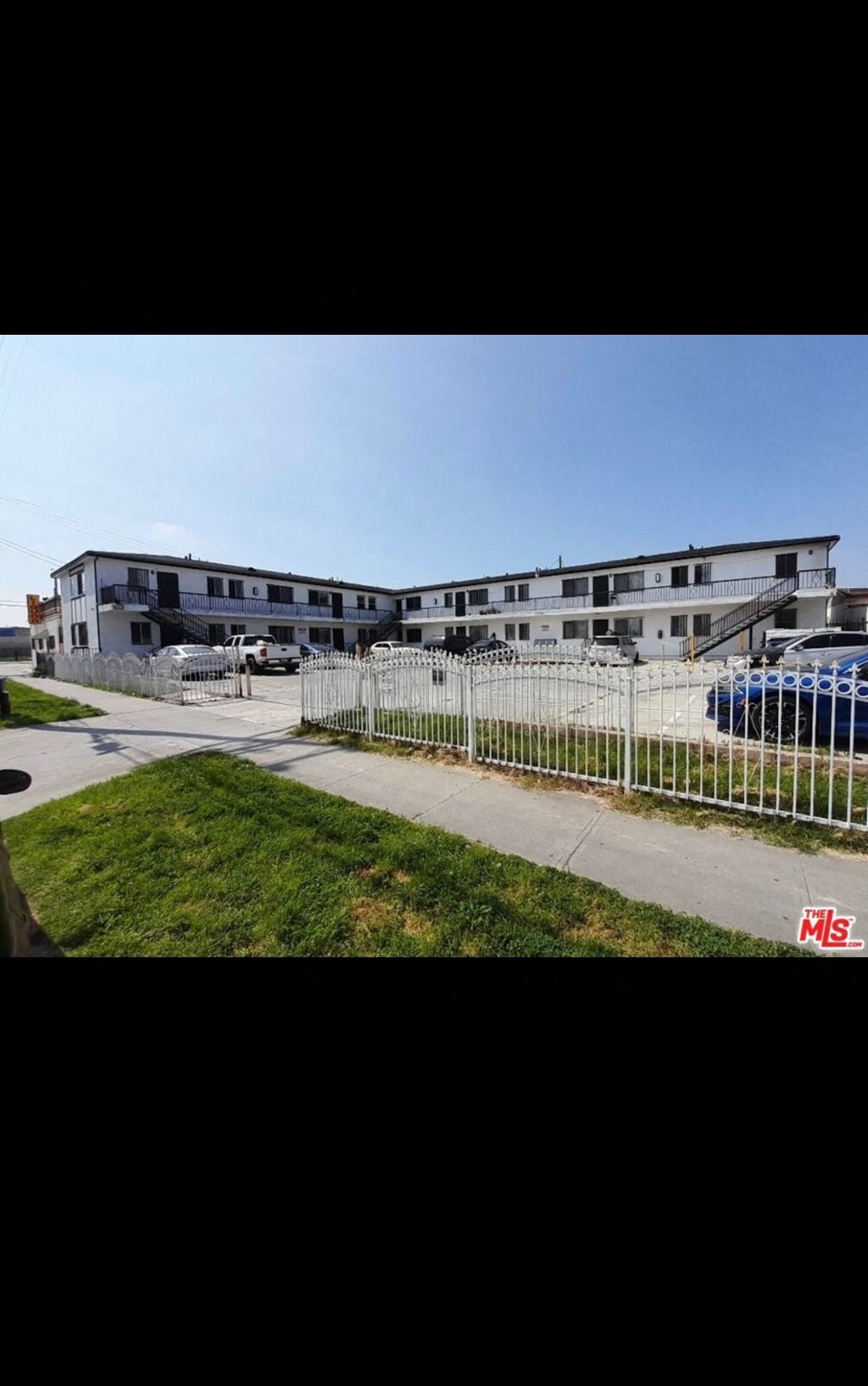 an apartment building with a fence in front of it