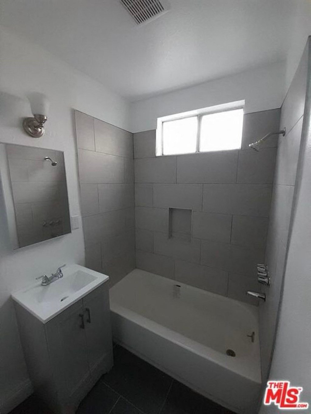 a bathroom with a tub and a sink and a window
