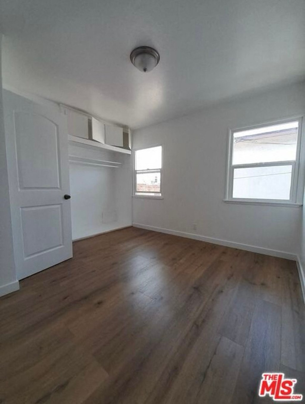 an empty living room with white walls and wood floors