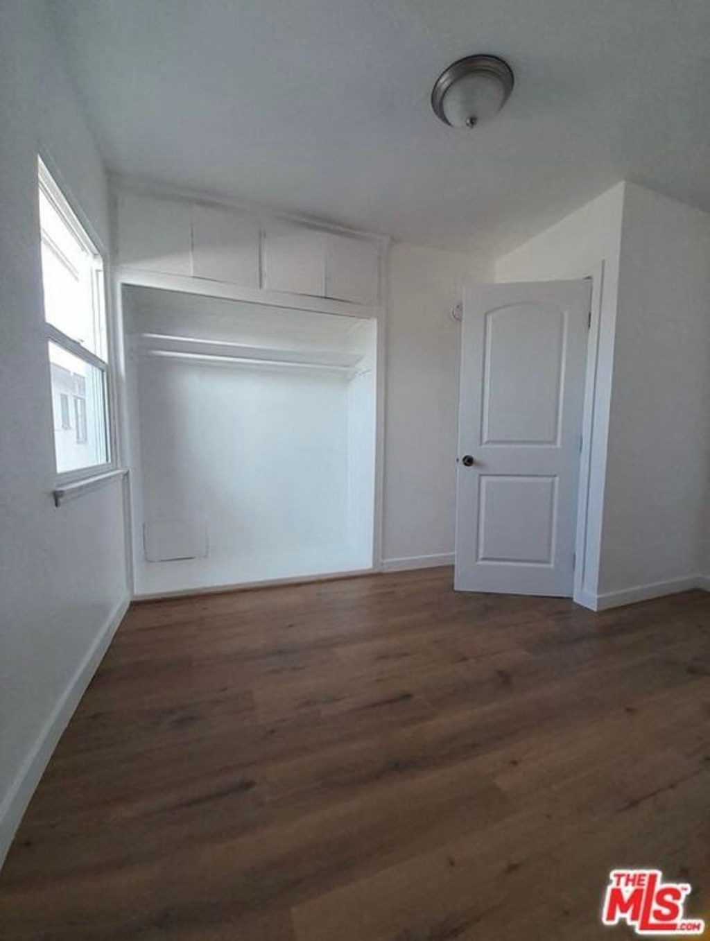 an empty room with white walls and a wooden floor