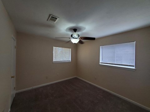 a bedroom with a ceiling fan and a window