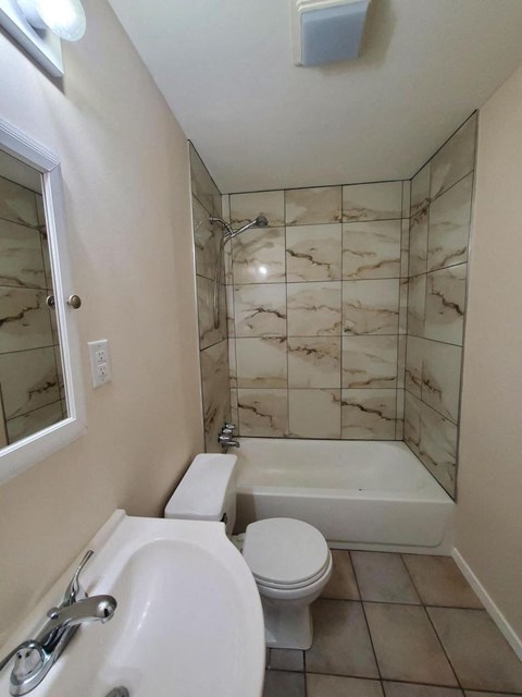 a bathroom with a toilet and a tub and a sink