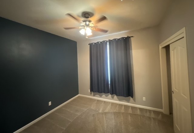 a empty room with a ceiling fan and a curtain