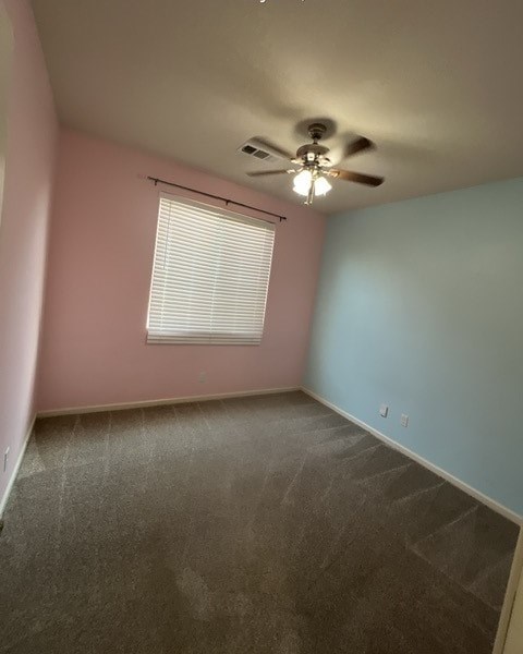 an empty room with a ceiling fan and a window