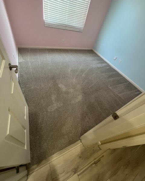 a room with a carpeted floor and a door