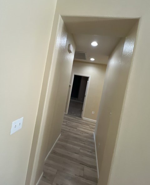 a hallway with a wooden floor and a door