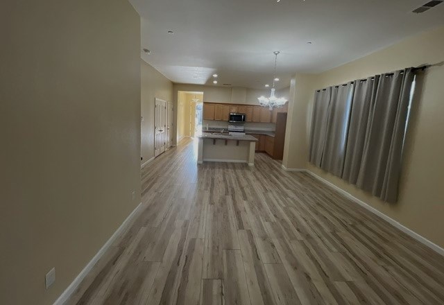 an empty living room and kitchen with wood flooring