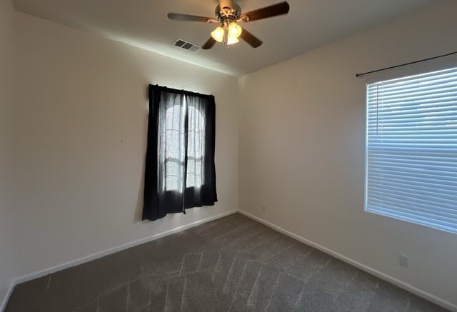an empty living room with a ceiling fan and a window