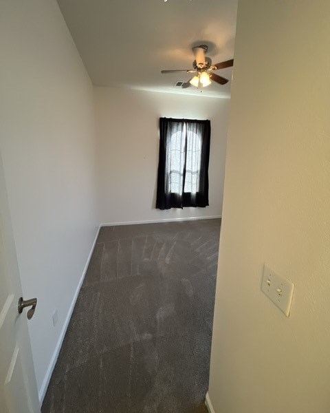 a empty room with a ceiling fan and a window