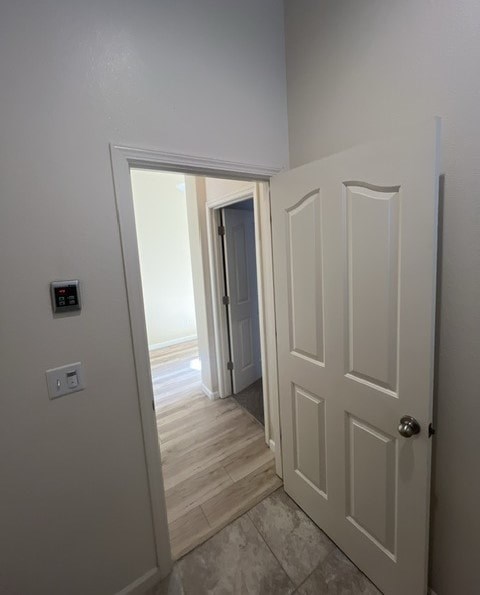 a hallway with a white door and a door to a bedroom