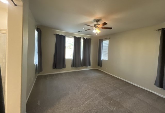 a empty living room with a ceiling fan and curtains