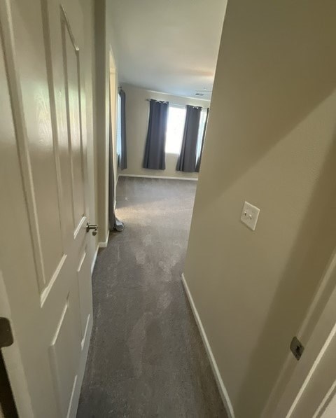 a hallway with a white door and a carpeted floor